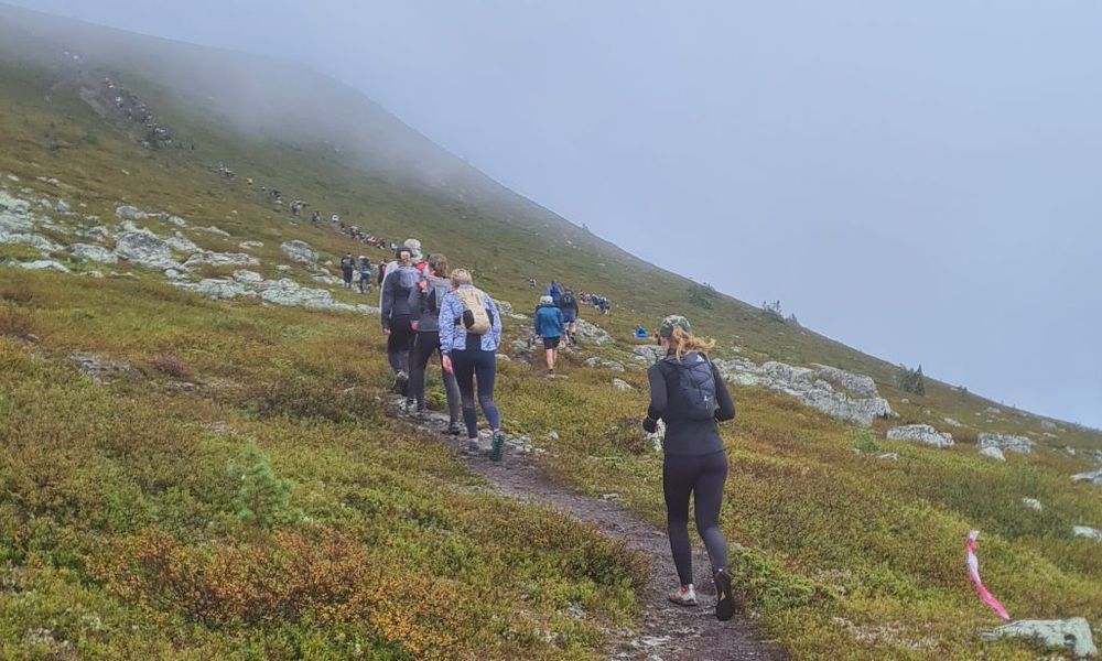 En ringlande kö uppför en brant fjällsluttning